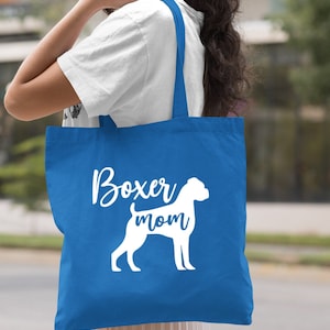 Puede incluir: Una bolsa de tela azul real con asas blancas y el texto "Boxer mom" y una silueta blanca de un boxer.