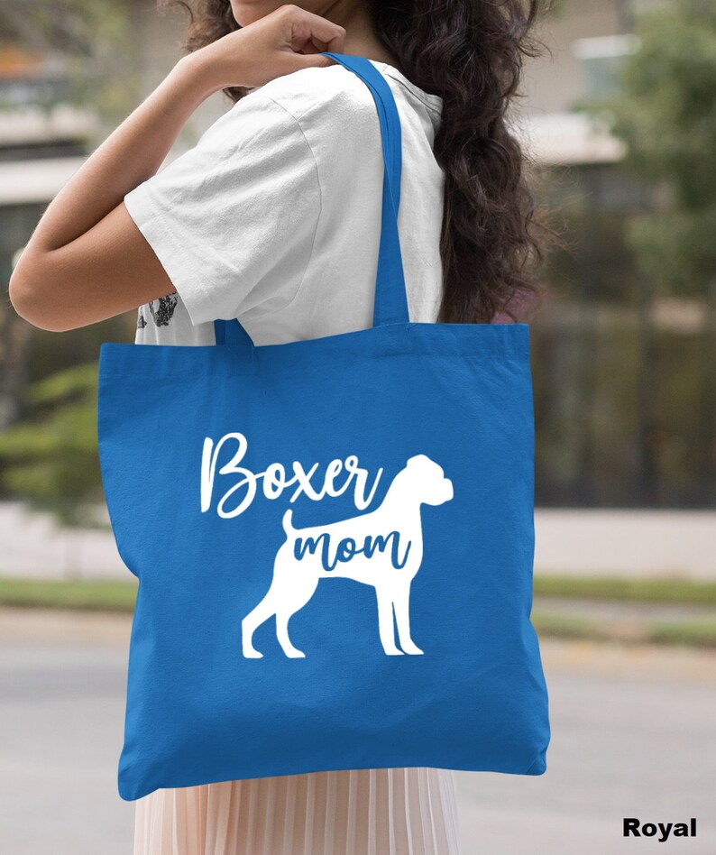 Puede incluir: Una bolsa de tela azul real con asas blancas y el texto "Boxer mom" y una silueta blanca de un boxer.