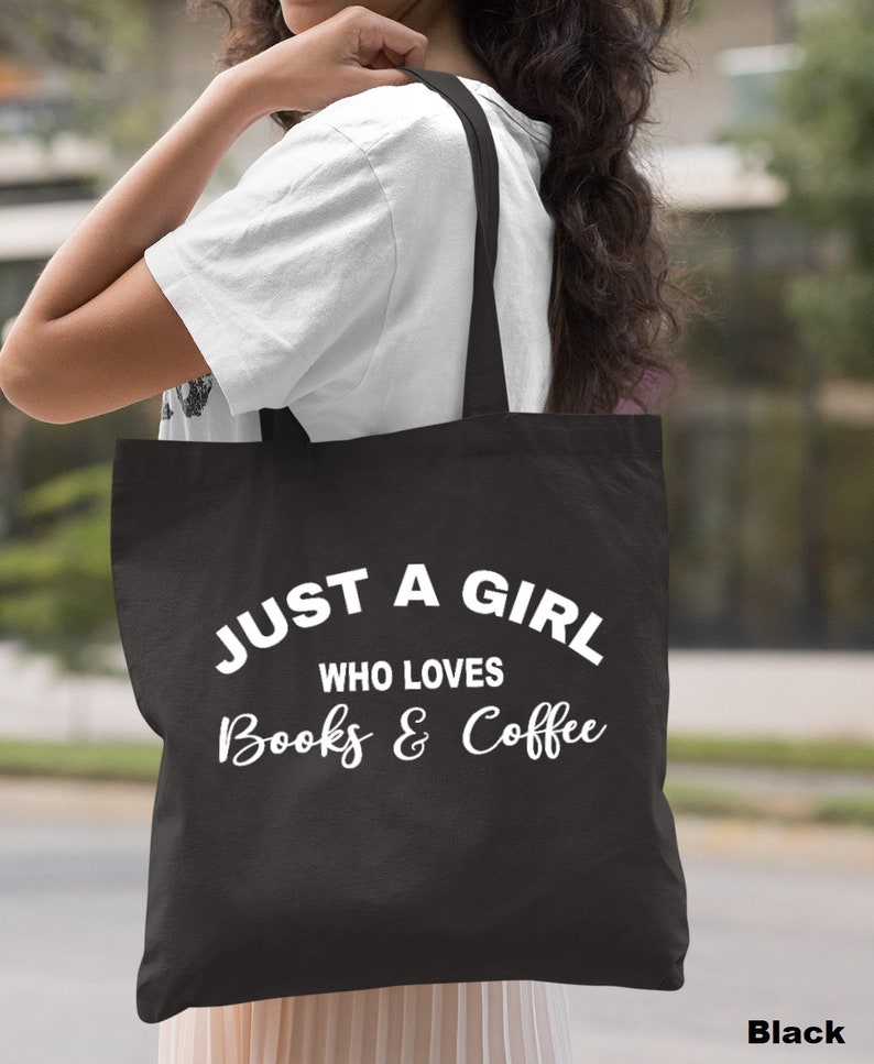 Puede incluir: Bolsa de tela negra con texto blanco que dice "Just a girl who loves books & coffee".
