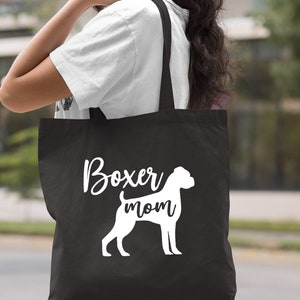 Puede incluir: Bolsa de tela negra con el texto blanco "Boxer mom" y una silueta blanca de un boxer.