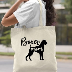 Puede incluir: Una bolsa de lona natural con texto negro y una silueta de un perro boxer. El texto dice "Boxer mom".