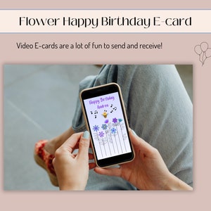 May include: A smartphone displaying a digital birthday card with a bee and flowers. The card reads "Happy Birthday Andrea".