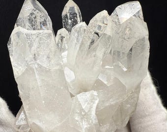 May include: A cluster of clear quartz crystals with a variety of sizes and shapes. The crystals are arranged in a natural formation, creating a unique and beautiful display.