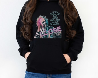 Puede incluir: Sudadera con capucha negra con un estampado gráfico de una persona con cabello rosa y el texto "Lets turn up the juice and see what shakes loose".