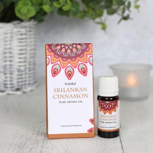 K&ouml;nnte beinhalten: Eine kleine Flasche reines Sri-Lanka-Zimt-Aroma&ouml;l in einer braunen Schachtel mit Mandala-Design. Die Schachtel tr&auml;gt die Aufschrift "Goloka" und "Nat&uuml;rlicher Raumduft".