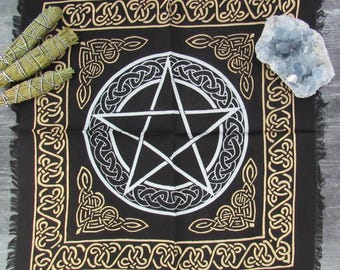 Può includere: Tovaglia da altare nera con un pentagramma bianco circondato da un bordo di nodo celtico dorato. La tovaglia ha un bordo con frange.