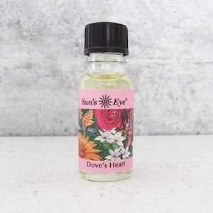 May include: A clear glass bottle with a black cap, filled with a yellow liquid. The bottle has a pink label with the text "Sun's Eye" and "Dove's Heart", along with floral illustrations in various colors.