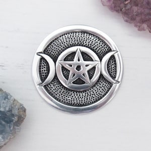 May include: Silver pendant featuring a pentacle with a triple moon symbol. The pendant has a textured surface.