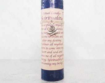 May include: A blue candle with a white label that reads "Ritual Candles Spirituality". The label also includes a quote about spirituality and a small silver charm of a meditating Buddha.