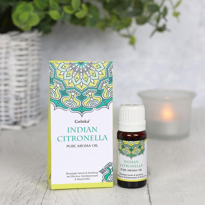 K&ouml;nnte beinhalten: Eine kleine Flasche Goloka Indian Citronella Pure Aroma Oil. Die Flasche ist aus klarem Glas mit einem wei&szlig;en Verschluss und einem gr&uuml;n-gelben Etikett. Das Etikett hat ein Mandala-Design und den Text "Goloka Indian Citronella Pure Aroma Oil" in Schwarz. Der Text "Pleasingly Sweet & Soothing. An Effective Antidepressant & Mood Lifter" befindet sich ebenfalls auf dem Etikett.