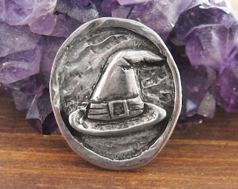 Piedra de bolsillo de peltre con forma de sombrero de bruja