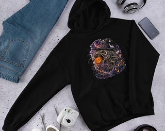 Può includere: Una felpa nera con cappuccio caratterizzata da una stampa grafica di un pesce gatto scheletrico con un cappello da strega, che tiene in bocca una zucca arancione luminosa, circondato da fumo viola, lune crescenti e caramelle a forma di mais.