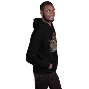 K&ouml;nnte beinhalten: Ein schwarzer Kapuzenpullover mit einem Grafikdruck eines skelettierten Fisches, der vor einem orangefarbenen Mond aus dem Wasser springt. Das Design zeigt Schilf und ein kleines Holzschild mit dem Text "BAD FISHING DAY" in einem dunklen Stil.