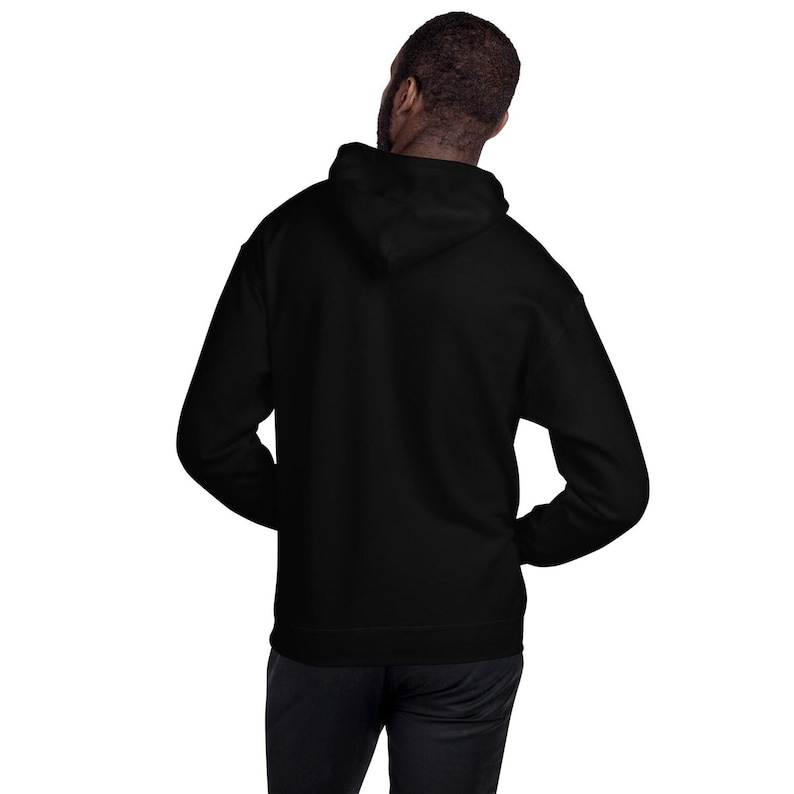 K&ouml;nnte beinhalten: Ein einfarbiger schwarzer Kapuzenpullover mit langen &Auml;rmeln und einer Kapuze. Das Kleidungsst&uuml;ck ist von hinten zu sehen und zeigt den schlichten schwarzen Stoff des R&uuml;ckenteils und der Kapuze. Der Pullover hat eine Standardpassform mit gerippten B&uuml;ndchen.