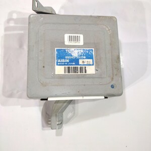 May include: A gray automotive computer module with a blue and white label that reads "AISIN" and "MADE IN JAPAN". The module has a barcode and the number "89540-35050". It has metal brackets for mounting.