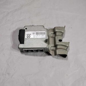 May include: A gray Nissan automotive control module with the text "NISSAN 00" and "Hitachi Automotive Products" printed on it.