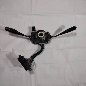 Pode incluir: Interruptor de coluna de direção de carro de plástico preto com três alavancas e um chicote de fiação.