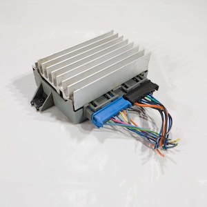 Puede incluir: Un componente electrónico gris con un disipador de calor plateado y varios cables conectados a él. Los cables son de varios colores, incluyendo azul, verde, rojo y amarillo.