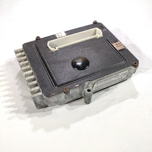 May include: A white ceramic mug with a black handle and the text "But First, Coffee" in a handwritten style. The mug is on a white surface. The mug is approximately 4 inches tall.