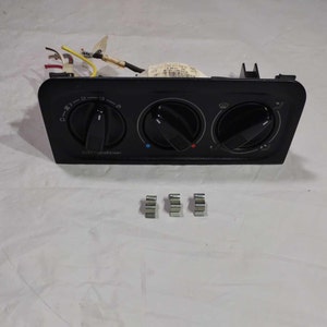 May include: Black plastic car air conditioning control panel with three knobs and the text "Air Condition" printed on the front. The panel has a blue, red, and white indicator light. Four silver metal clips are also included.