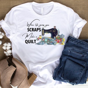 May include: White t-shirt with a sewing machine and fabric scraps design. The text reads "When life gives you scraps make a quilt".