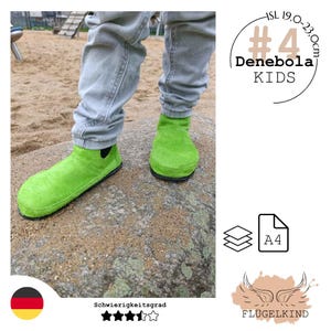 May include: Bright lime green suede ankle boots with black elastic side panels and thin black soles. The text #4 Denebola KIDS ISL 19.0-23.0cm is visible. The boots are worn with light gray pants, standing on a large stone surface.