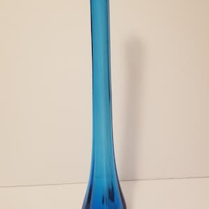 May include: A tall, slender, blue glass vase with a flared, rounded bottom and a scalloped top.