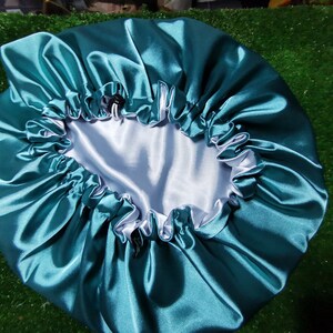 Pu&ograve; includere: Cappello in raso verde acqua con interno bianco e bordo arricciato. Il cappello &egrave; progettato per proteggere i capelli durante il sonno. Il raso riduce l'attrito e previene la rottura.