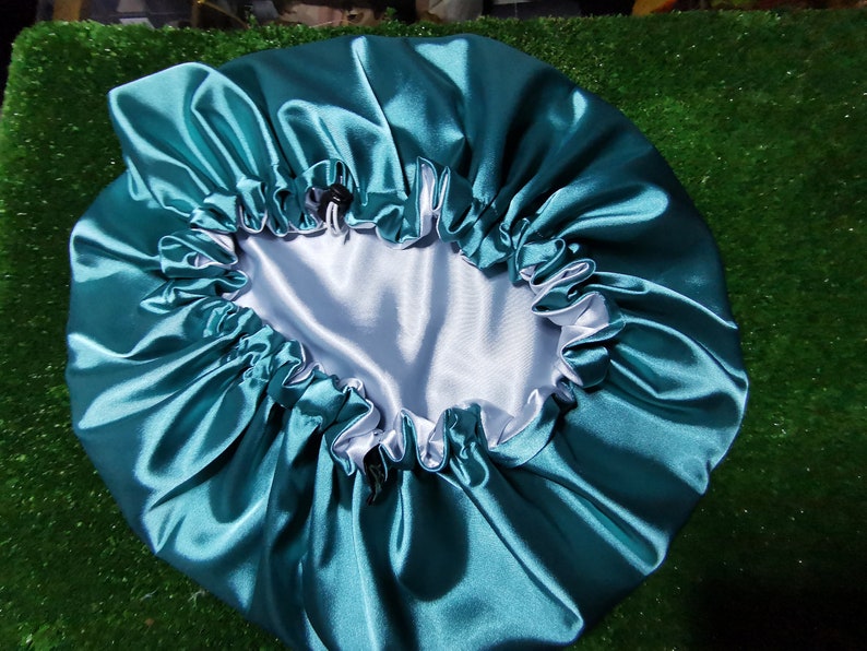 Pu&ograve; includere: Cappello in raso verde acqua con interno bianco e bordo arricciato. Il cappello &egrave; progettato per proteggere i capelli durante il sonno. Il raso riduce l'attrito e previene la rottura.