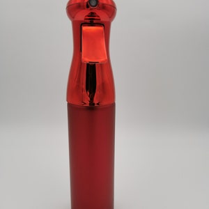 May include: A red metal spray bottle with a trigger nozzle. The bottle has a shiny, metallic finish.