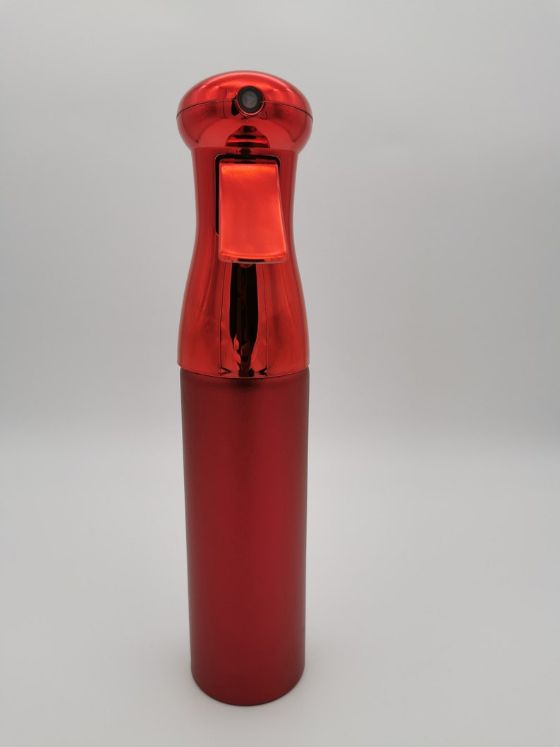 May include: A red metal spray bottle with a trigger nozzle. The bottle has a shiny, metallic finish.