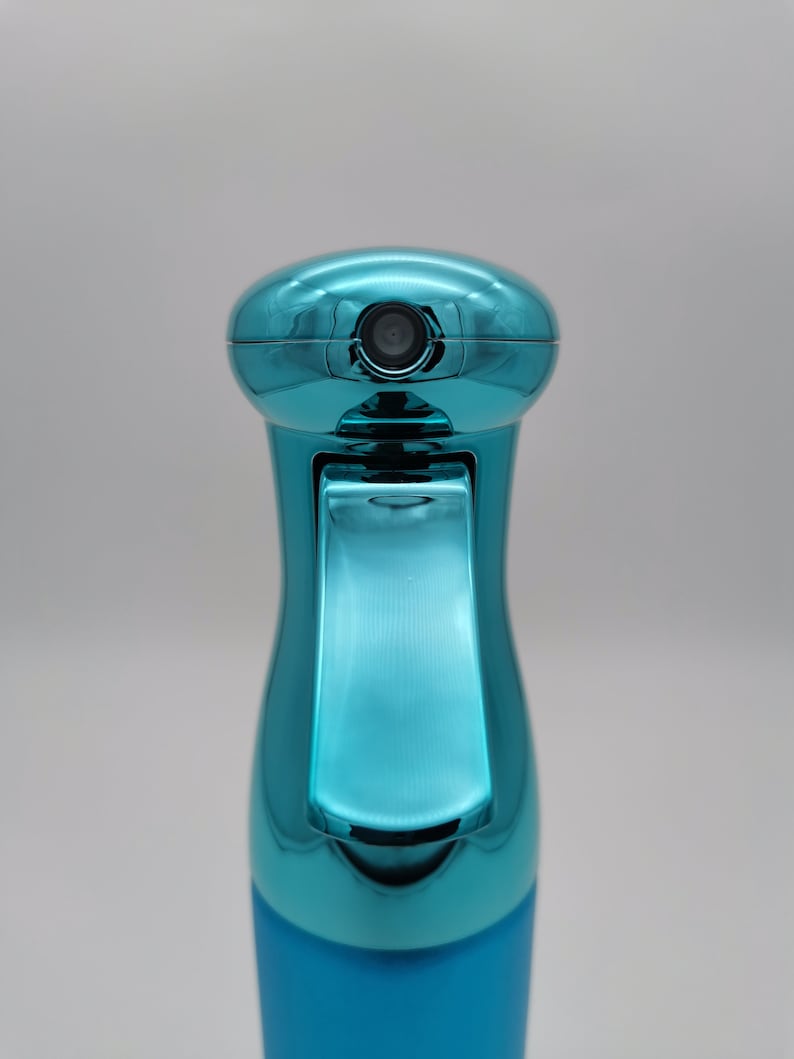 May include: A turquoise blue plastic spray bottle with a metallic finish. The bottle has a trigger sprayer and a clear nozzle.