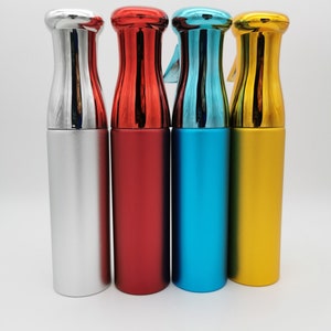 May include: Four spray bottles with different colored caps and bodies. The bottles are silver, red, blue, and gold.