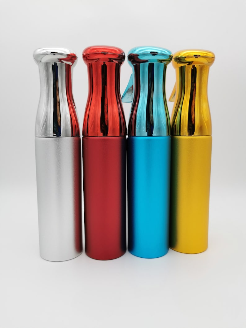 May include: Four spray bottles with different colored caps and bodies. The bottles are silver, red, blue, and gold.