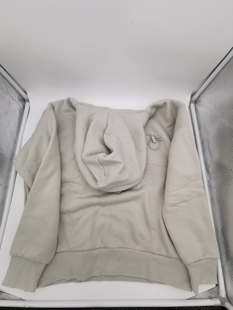May include: A light gray hooded sweatshirt with a drawstring hood and long sleeves.