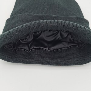May include: Black beanie with a black satin lining. The beanie is folded down to show the lining.