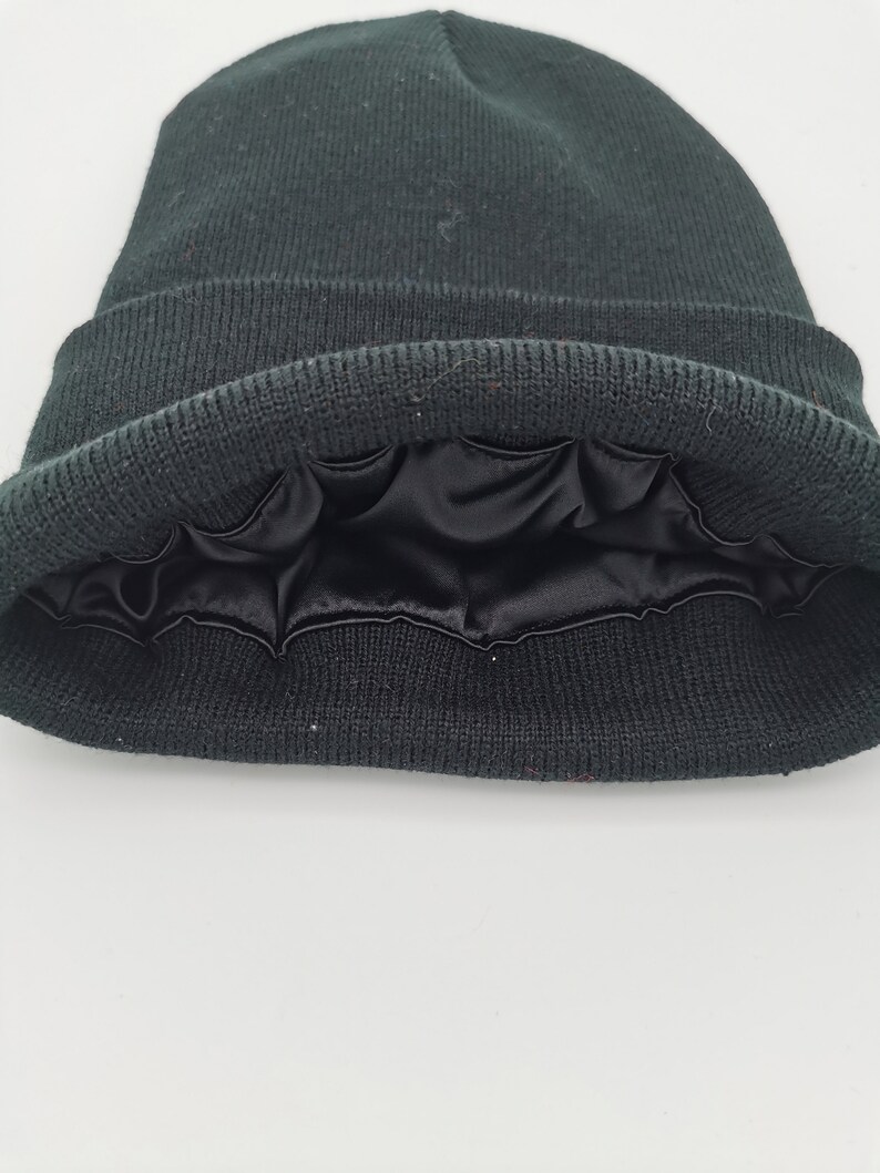May include: Black beanie with a black satin lining. The beanie is folded down to show the lining.