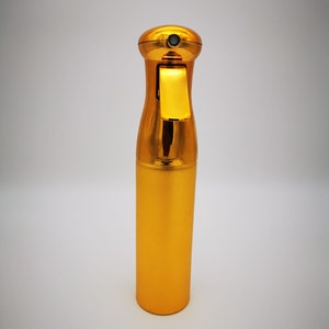 May include: A gold-colored spray bottle with a black trigger and a gold cap.