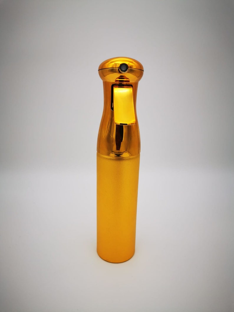 May include: A gold-colored spray bottle with a black trigger and a gold cap.