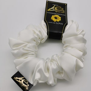 May include: White satin scrunchie with a black tag that reads "African Store Handmade Scrunchie made with LOVE".
