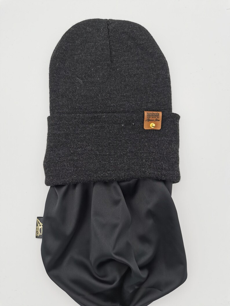 May include: A black beanie with a brown leather patch that says "Handmade with love for the fearless soul". The beanie has a matching black neck gaiter.