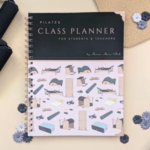 May include: A pink and black spiral bound notebook with the title "Pilates Class Planner for Students & Teachers" by "Maren Mara Art". The cover features illustrations of Pilates equipment.