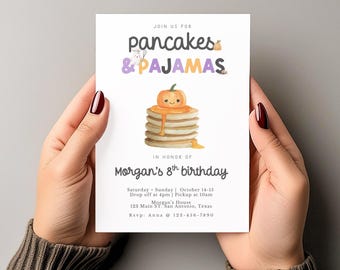 Könnte beinhalten: Eine weiße Einladungskarte, die von Händen gehalten wird, mit dem Text "pancakes & pajamas" und einem Stapel Pfannkuchen, der mit einem Kürbis belegt ist. Die Karte ist für Morgans 8. Geburtstag, mit Veranstaltungsdetails und RSVP-Informationen.