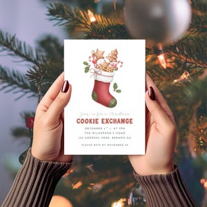 May include: A Christmas cookie exchange invitation held by hands. The invitation features a red and green Christmas stocking filled with cookies and candy canes. The text reads "Join us for a Christmas Cookie Exchange" with event details.