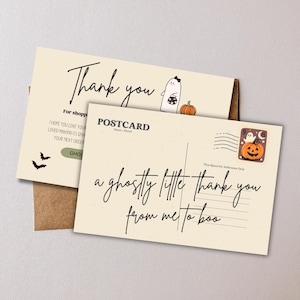 May include: Two Halloween-themed postcards. One says "Thank you" with a ghost and pumpkin illustration. The other says "a ghostly little thank you from me to boo." Includes a stamp with a jack-o'-lantern.