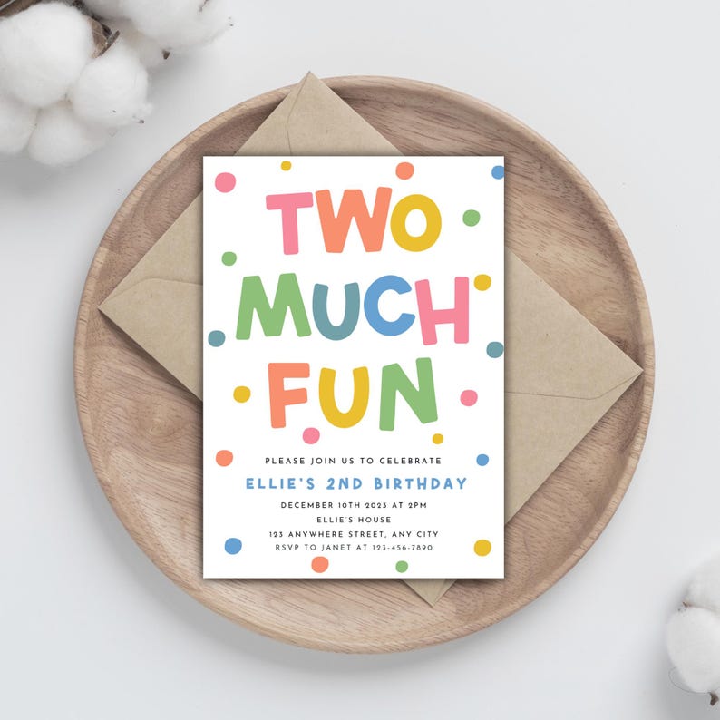 May include: A colorful birthday invitation with the words "TWO MUCH FUN" in large, playful letters. The invitation includes details for Ellie's 2nd birthday, set on a wooden plate with a kraft paper envelope.