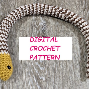 May include: A crochet snake pattern in brown and white with a yellow head. The pattern is available as a digital download. The text "DIGITAL CROCHET PATTERN" is written on a white background.