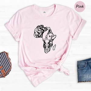May include: A pink t-shirt with a black outline of the continent of Africa, with the heads of a lion, rhino, and elephant forming the shape of the continent.