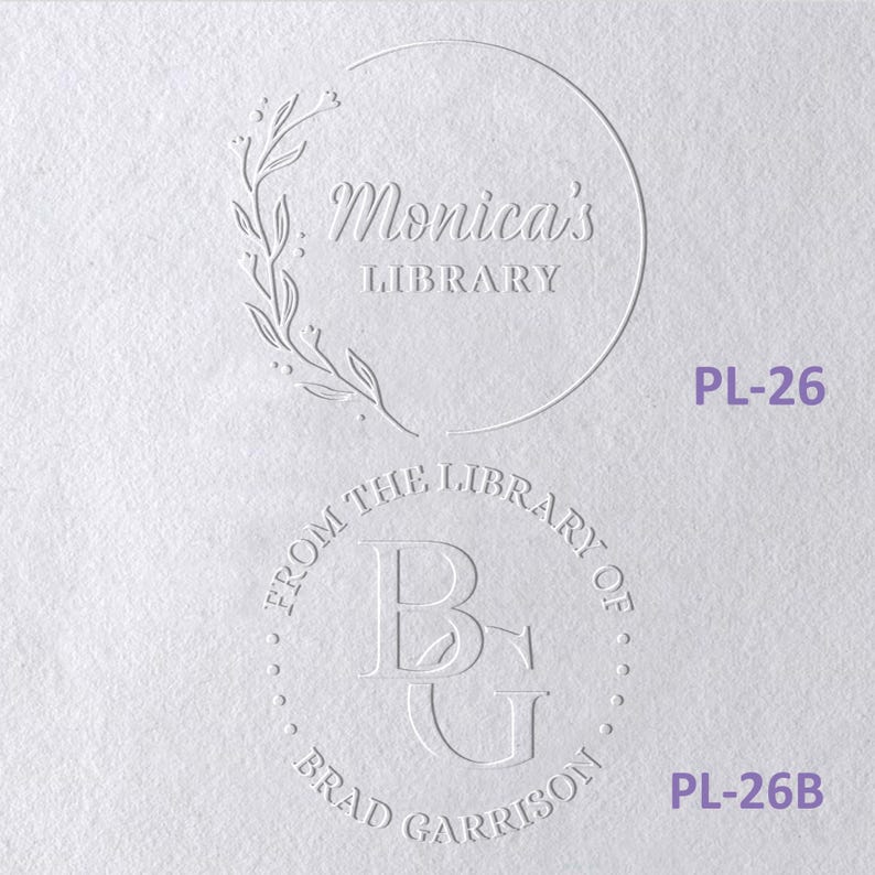 May include: Two circular embossed designs on white paper. The top design features a floral branch and the text Monica's LIBRARY. The bottom design features the initials BG surrounded by the text FROM THE LIBRARY OF BRAD GARRISON. Labels PL-26 and PL-26B appear in purple text.