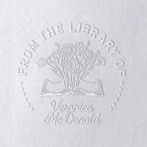 May include: White embossed stamp with the text "From the Library of Veronica McDonald" and a design of a book with flowers on top.